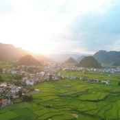 Thung lũng xanh và khu dân cư nằm giữa các dãy núi đá trong ánh chiều tháng 8